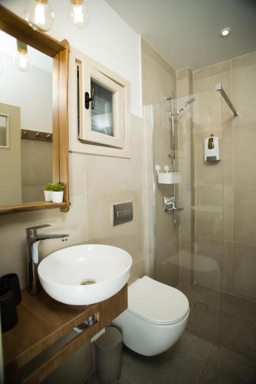 a bathroom with a sink and a toilet and a shower at Horizon Hotel Kalymnos in Myrties