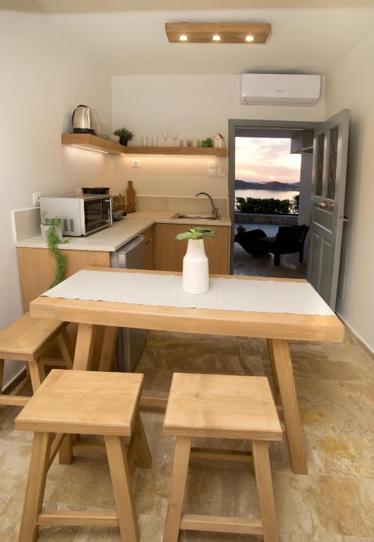a kitchen with a large wooden table and benches at Horizon Hotel Kalymnos in Myrties