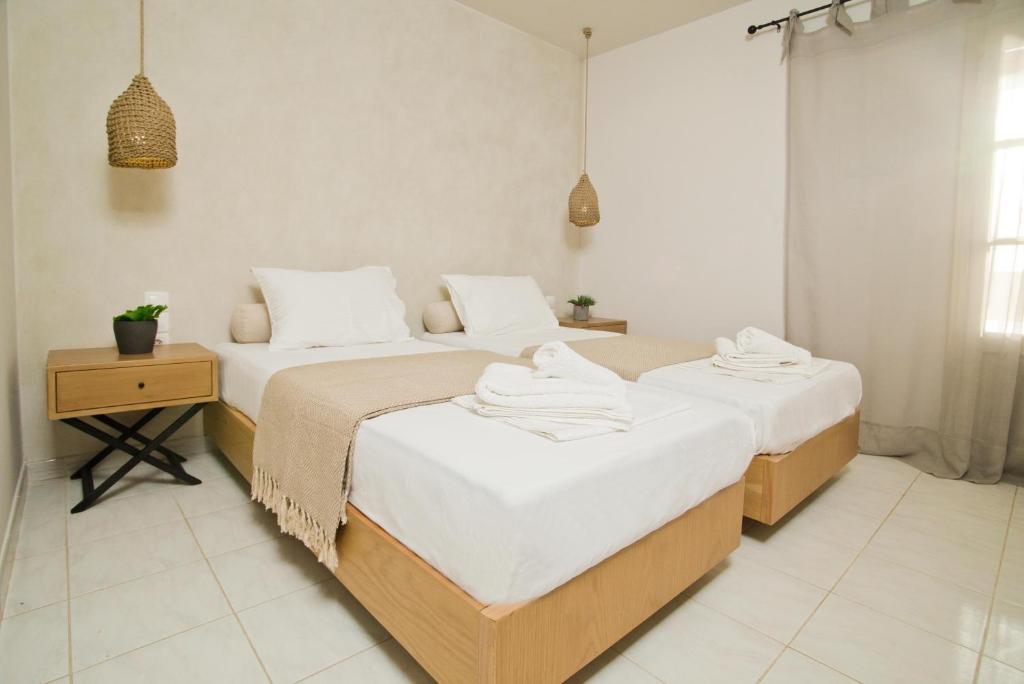 two beds in a room with white walls at Horizon Hotel Kalymnos in Myrties