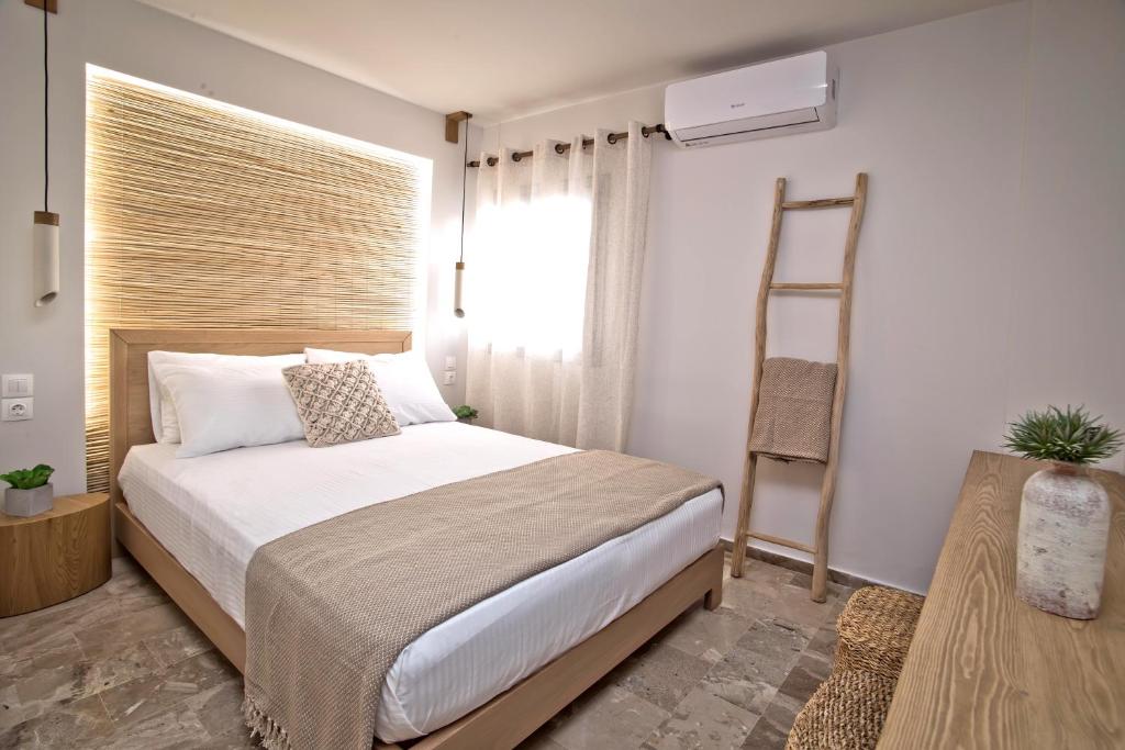 a bedroom with a bed with a ladder and a window at Horizon Hotel Kalymnos in Myrties