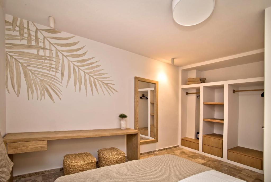 a bedroom with a bed and a mirror at Horizon Hotel Kalymnos in Myrties