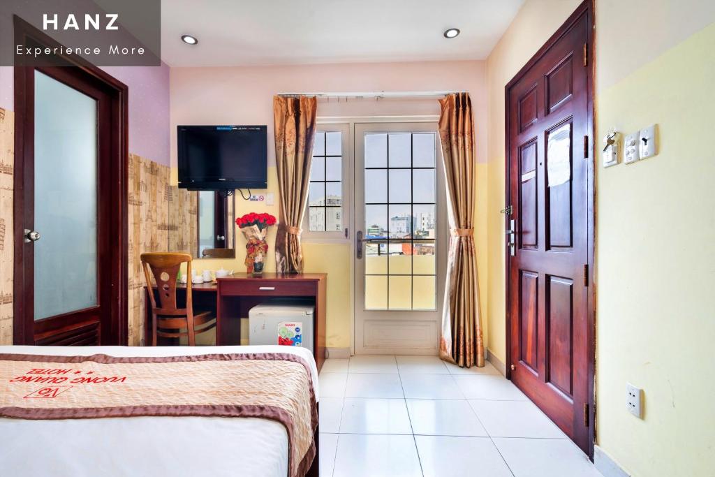 - une chambre avec un lit, un bureau et une fenêtre dans l'établissement HANZ Vuong Quang Hotel, à Hô-Chi-Minh-Ville