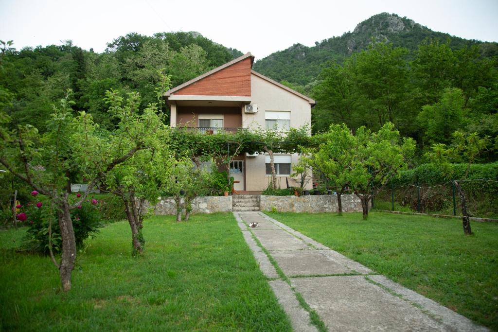 a house in a field with trees in front of it at Flamingo in Virpazar