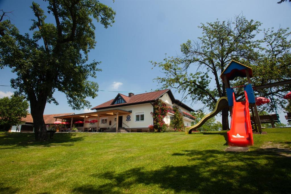 einen Spielplatz in einem Hof mit einem Haus in der Unterkunft Gasthof-Pension Weninger in Paldau