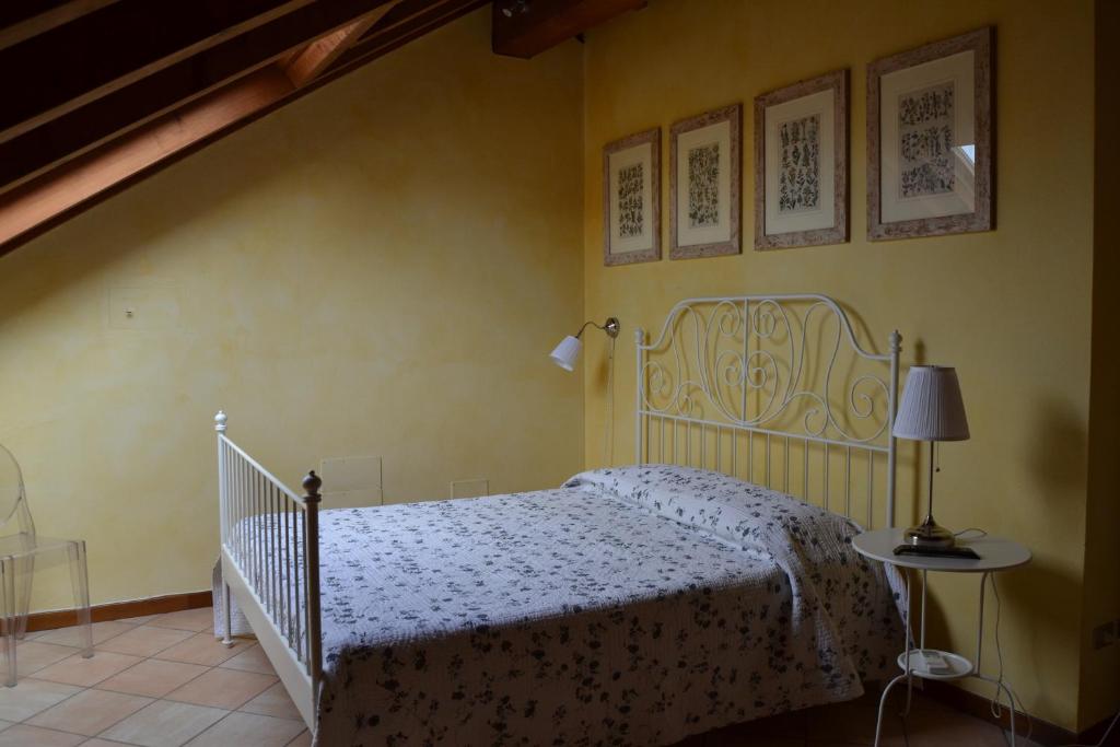 a bedroom with a white bed and a staircase at B&B Il Torrazzo in Crema