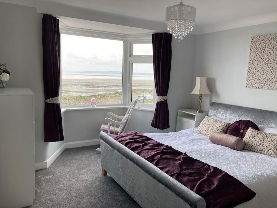 Un dormitorio con una cama y una ventana grande. en fabulous sea views and sunsets, en Morecambe