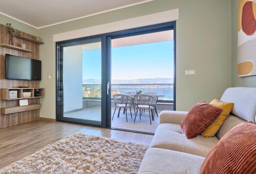 a living room with a couch and a sliding glass door at Zsuzsa's Place - peaceful sea view flat in Slatine