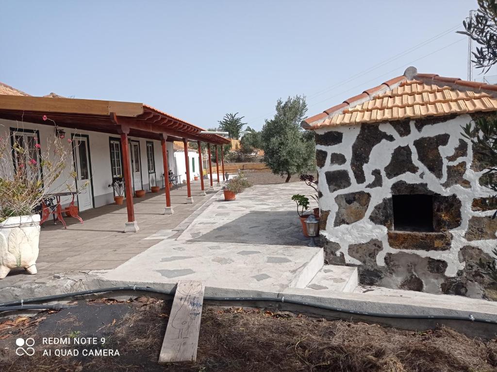 un bâtiment avec un mur en pierre à côté d'un bâtiment dans l'établissement Casa PESTANA, à Fuencaliente de la Palma