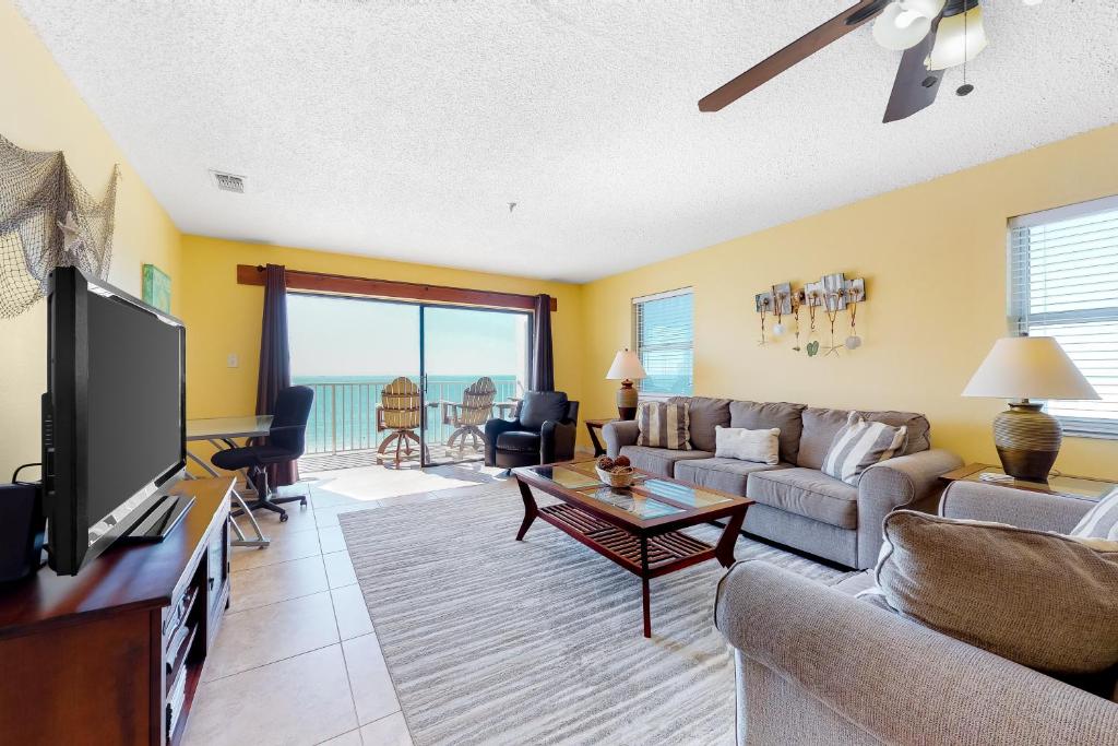 a living room with a couch and a tv at Sea Breeze 608 in St. Pete Beach