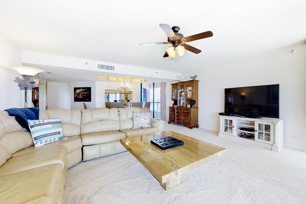 a living room with a couch and a ceiling fan at Crescent Beach Club I 5A in Clearwater Beach