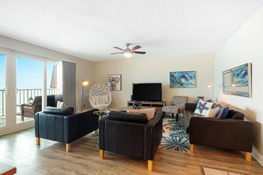 uma sala de estar com dois sofás e uma televisão em Holiday Villas II 413 em Clearwater Beach