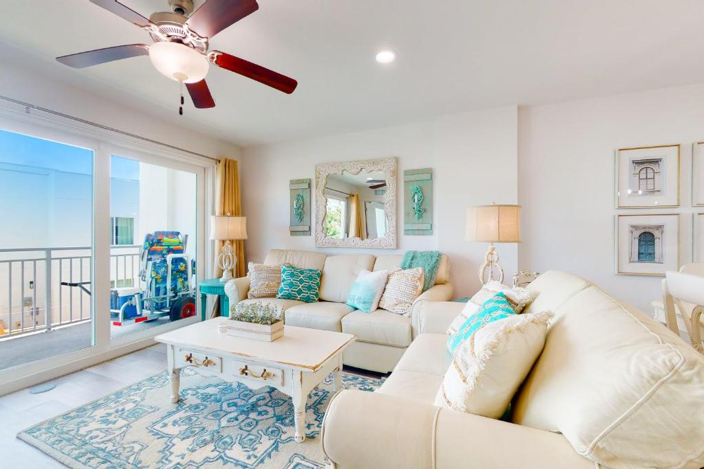 a living room with a couch and a ceiling fan at Madeira del Mar 303 in St Pete Beach