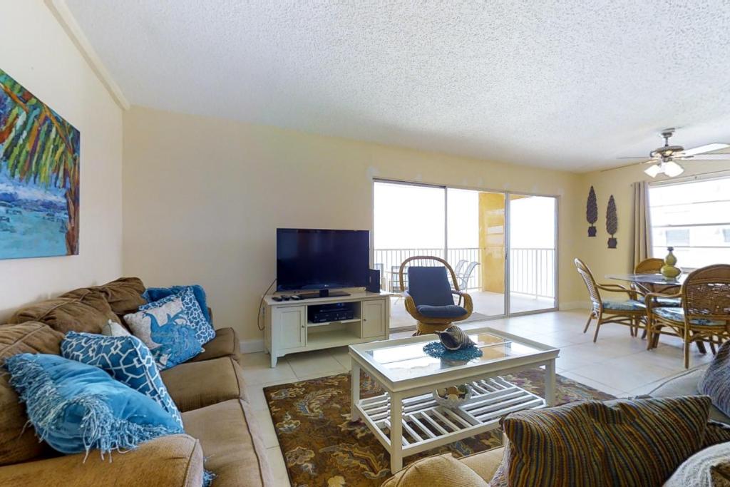 a living room with a couch and a tv at Holiday Villas III 505 in Clearwater Beach