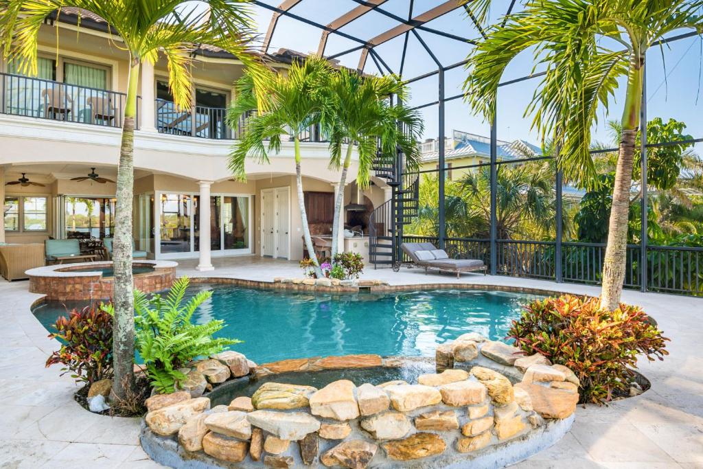 una casa con piscina y palmeras en Villa De La Mar at Casey Key, en Nokomis