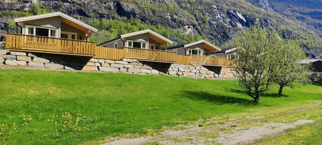 a row of houses on a stone wall in a field at Lunde Camping in Aurland