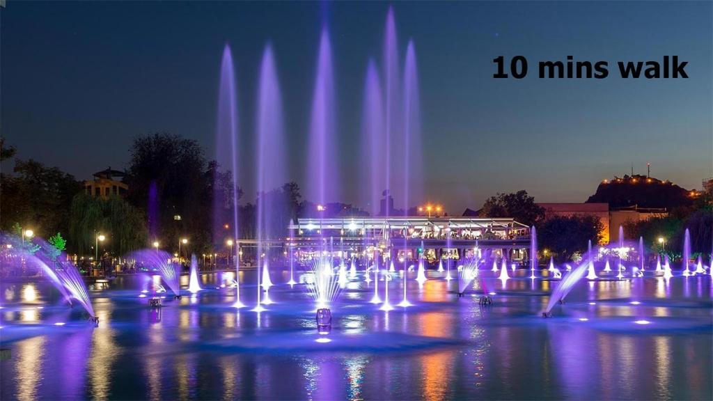 a group of water fountains in a city at night at Ruski Boulevard in Plovdiv