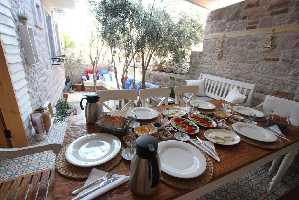un tavolo in legno con piatti di cibo sopra di Cesmeli Han a Ayvalık