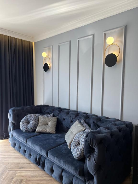 a blue couch in a living room with two pillows at Family & Business Sauna Tężnia Apartments No 20 Leśny nad Zalewem Cedzyna - 1 Bedroom with Private Sauna, Bath with Hydromassage , Terrace, Parking, Catering Options in Kielce
