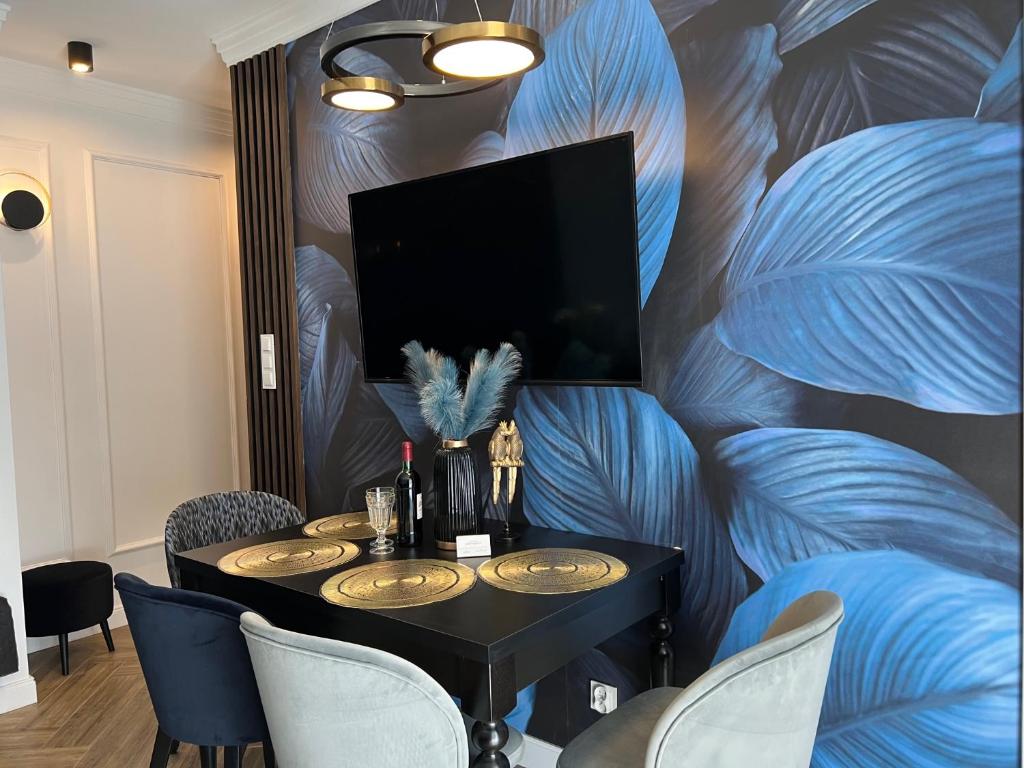 a dining room with a table with chairs and a tv at Family & Business Sauna Tężnia Apartments No 20 Leśny nad Zalewem Cedzyna - 1 Bedroom with Private Sauna, Bath with Hydromassage , Terrace, Parking, Catering Options in Kielce