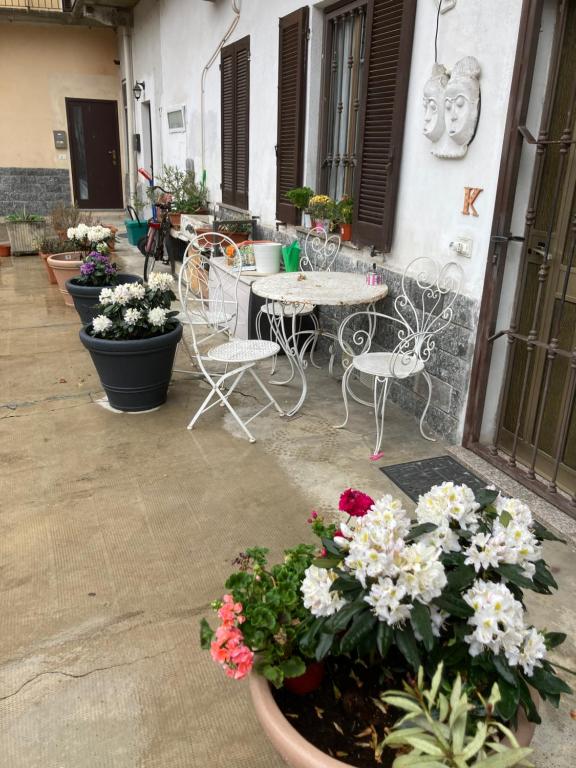 un patio con mesa, sillas y flores en Room Saronno + B&B en Saronno