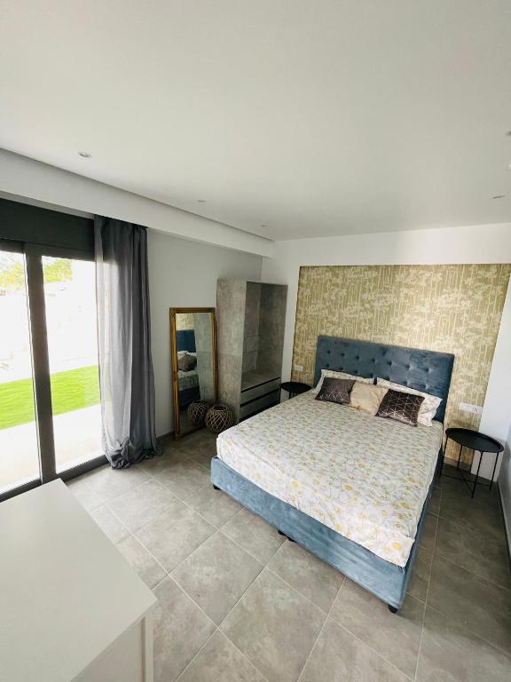 sypialnia z łóżkiem i dużym oknem w obiekcie Vixen Apartment w mieście Theologos