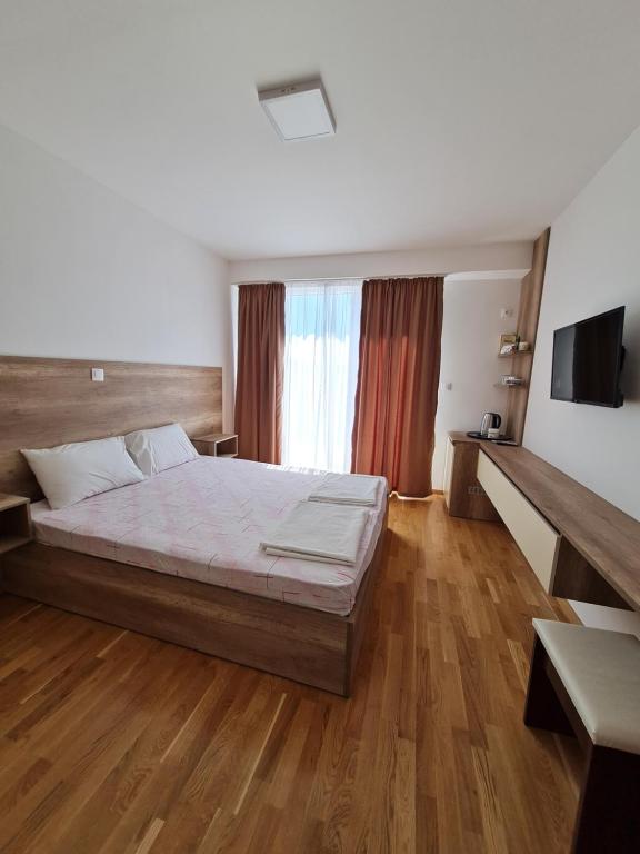 um quarto com uma cama grande e piso em madeira em Bojana Apartment Penthouse em Negotino