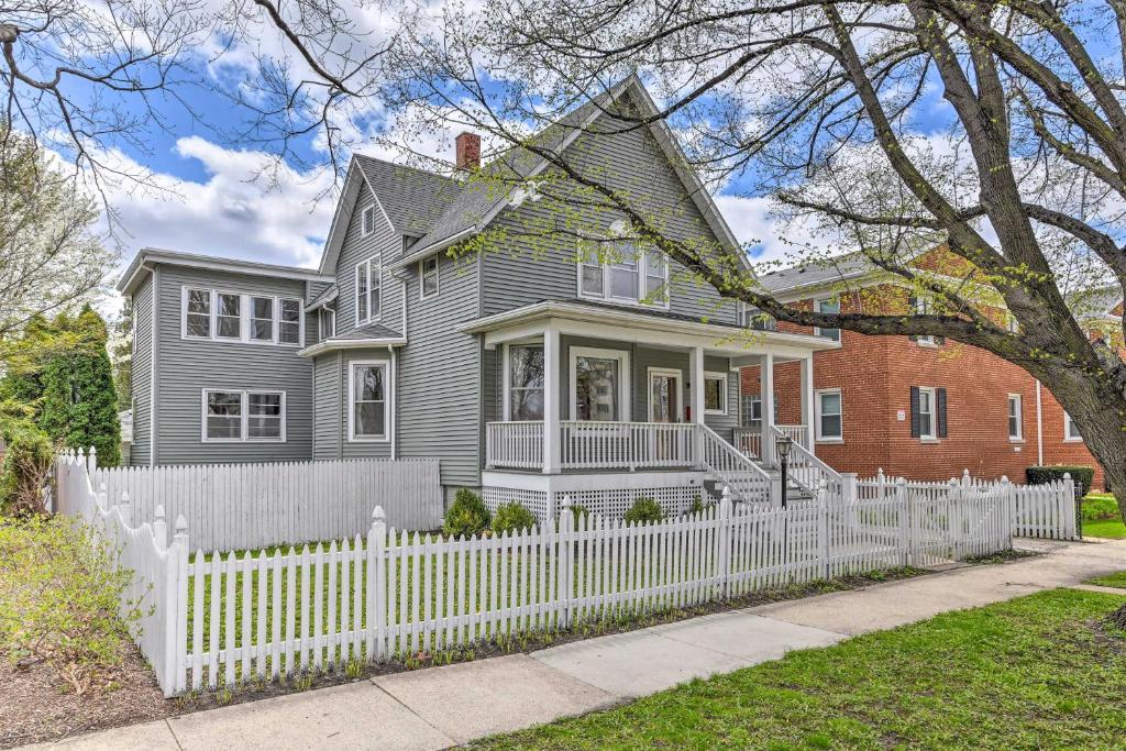 una casa gris con una valla blanca en Oak Park House - 11 Mi From Downtown Chicago! en Oak Park