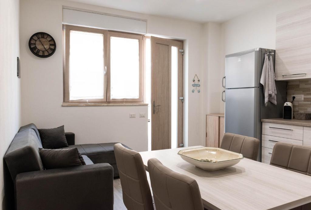 una cucina e un soggiorno con tavolo e frigorifero di CAUS Relax a Oristano