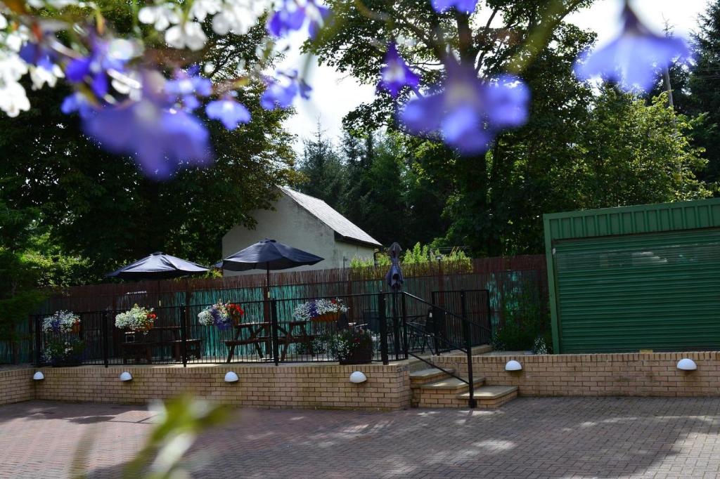 a fence with umbrellas and a table and chairs at The Dwelling Place in Irvine