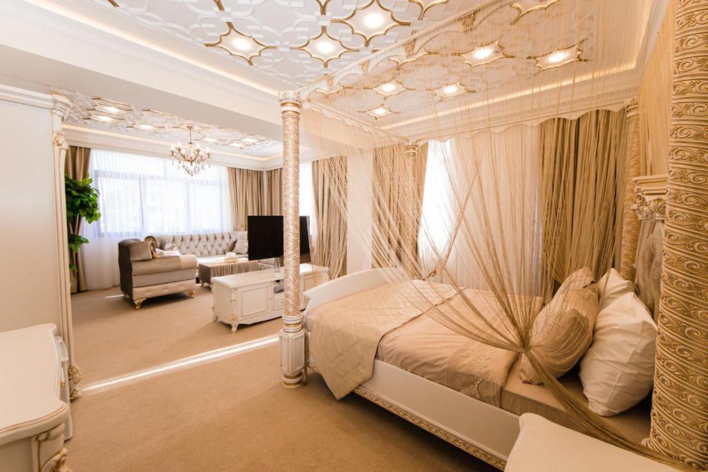 a bedroom with a canopy bed and a living room at Alfa Hotel in Baku
