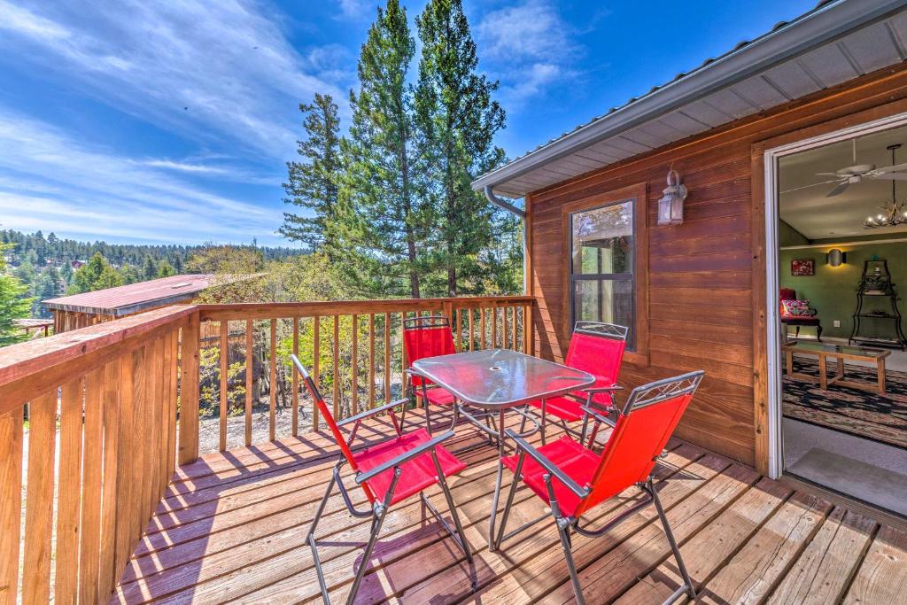 a deck with red chairs and a table at Cloudcroft Escape with Forest Views! in Cloudcroft