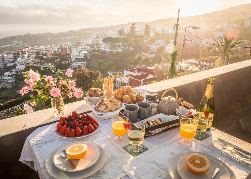 een tafel met eten en drinken en uitzicht op de stad bij Vista Del Drago in Icod de los Vinos