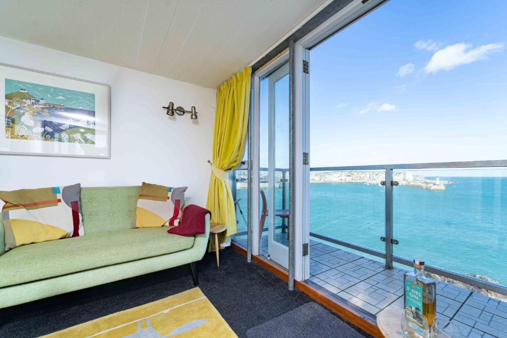 Una sala de estar con un sofá y vista al mar. en The Lighthouse, en St Ives