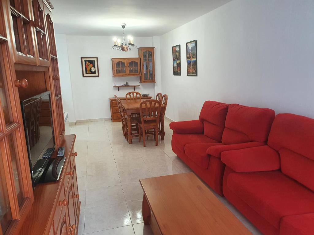 een woonkamer met een rode bank en een tafel bij Apartamento Casa Go in Torla