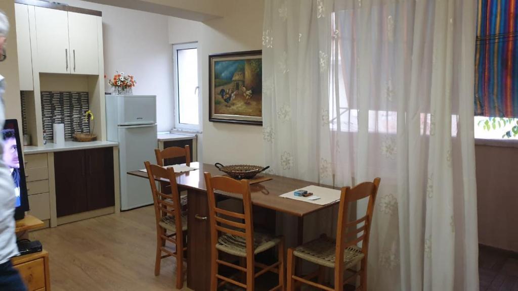 uma cozinha com mesa e cadeiras num quarto em Valentina's Apartment em Tirana