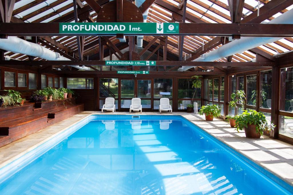 - une piscine dans un bâtiment avec toit dans l'établissement Rincón de los Andes Resort, à San Martín de los Andes