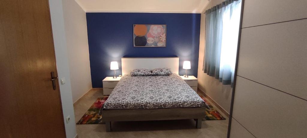 ein kleines Schlafzimmer mit einem Bett und zwei Nachttischen in der Unterkunft Apartmani Vugec in Vir
