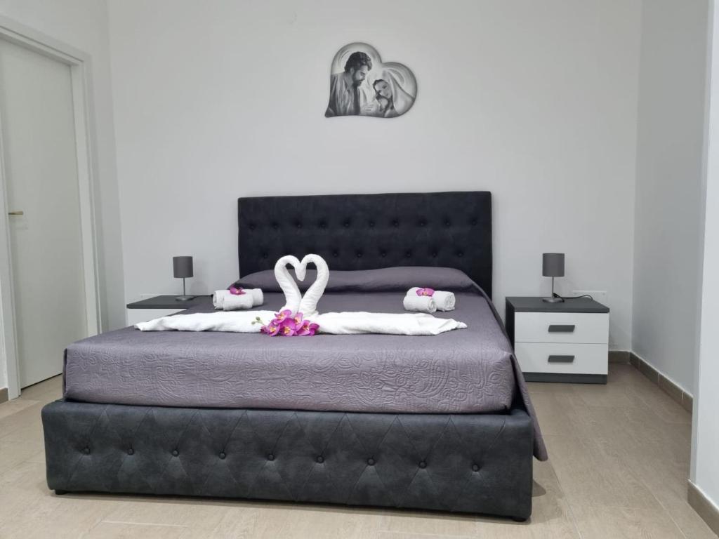 um quarto com uma cama grande e uma cabeceira preta em Appartamenti a Gallipoli em Gallipoli
