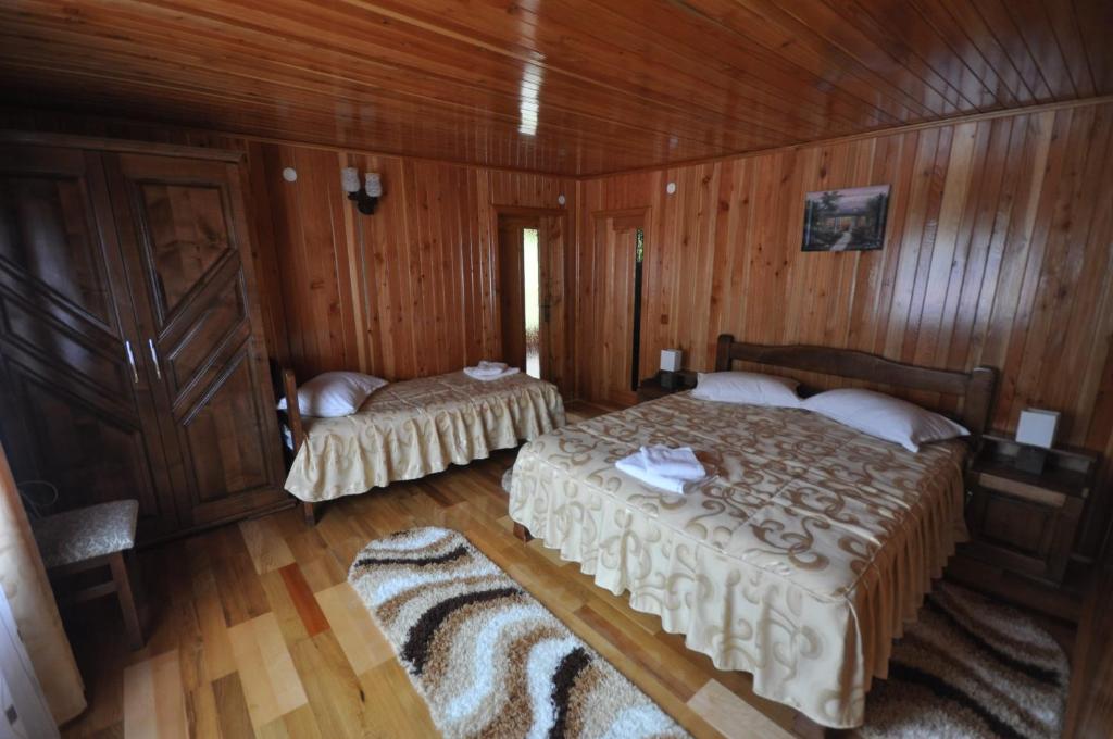 a bedroom with two beds in a wooden room at Cabana Sargetia in Costeşti