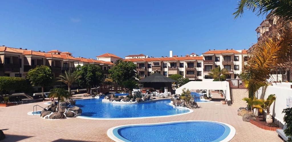 a resort with a large swimming pool in front of a building at 50 meters from the ocean in Costa Del Silencio