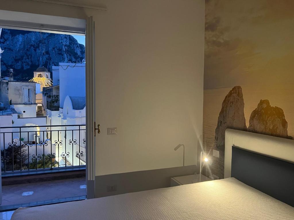 a bedroom with a bed and a window with a view at Domus Le Botteghe in Capri