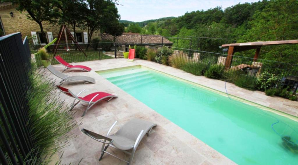 uma piscina com duas cadeiras e uma piscina em Villa de 5 chambres avec piscine privee jardin amenage et wifi a Divajeu em Divajeu