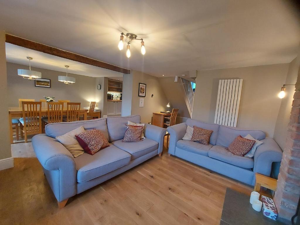 ein Wohnzimmer mit 2 Sofas und einem Esszimmer in der Unterkunft Luxurious 4 bedroom Cottage in the Yorkshire Dales in Richmond
