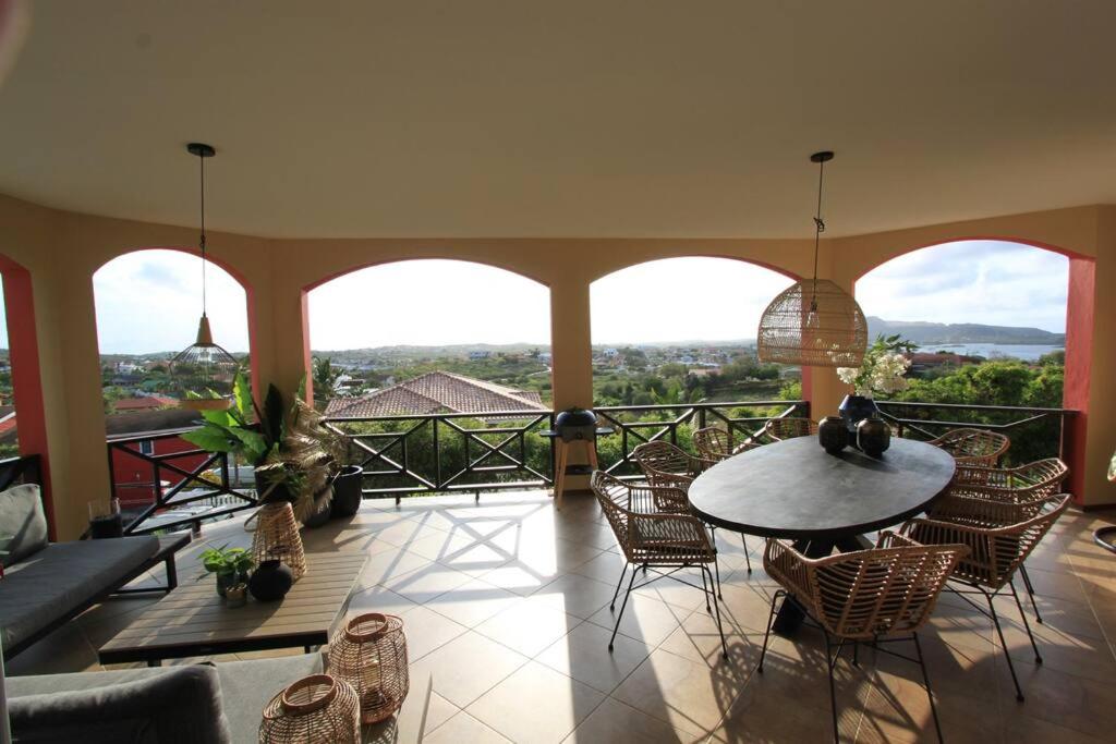 a room with a table and chairs on a balcony at Appartement Lora Jan Thiel Curacao in Jan Thiel