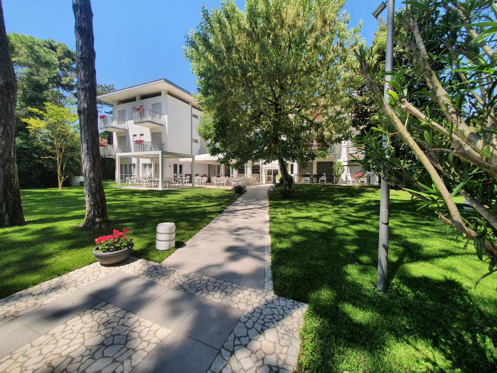 a house with a walkway in front of a yard at Hotel Eurovil Garni in Lignano Sabbiadoro