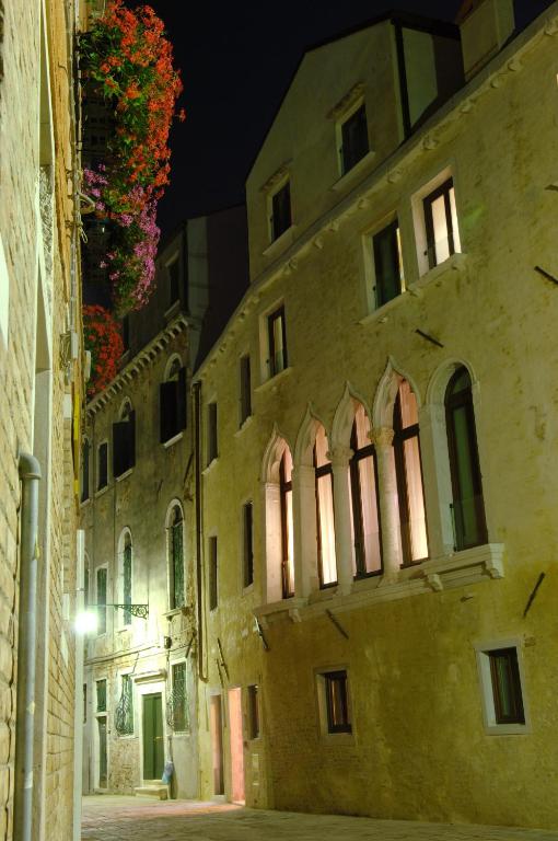stary budynek w alejce w nocy w obiekcie Hotel Ca' Zusto Venezia w Wenecji