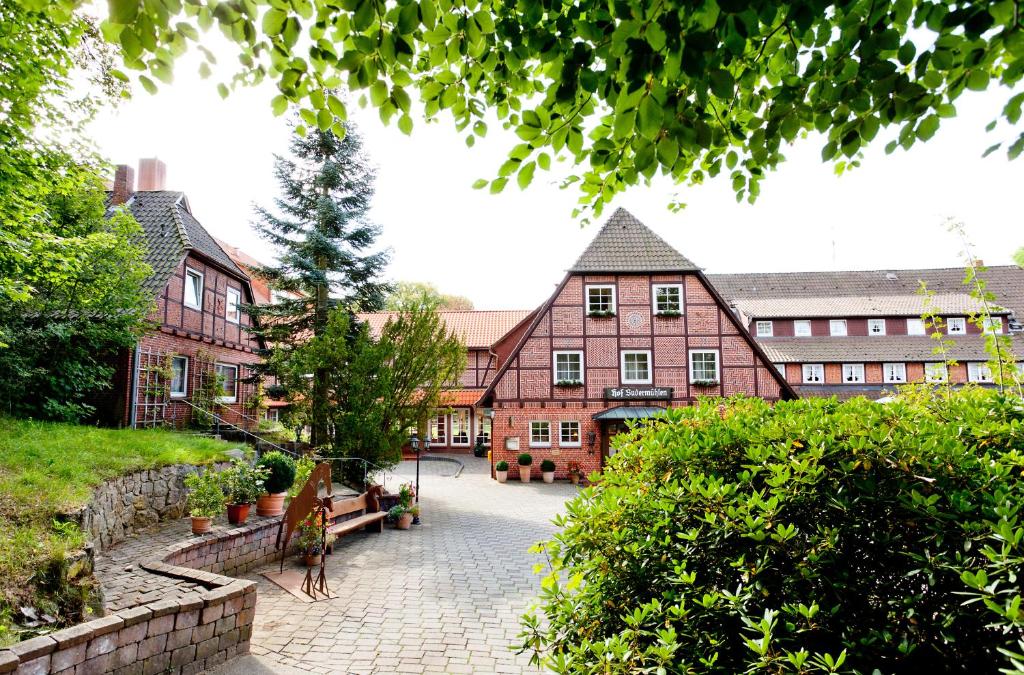 Eine Frau, die vor einem Gebäude steht. in der Unterkunft Hotel Hof Sudermühlen in Egestorf