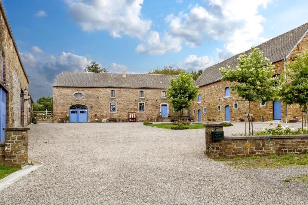 uma vista para o exterior de um grande edifício de pedra com uma entrada em Vakantieboerderij Ferme Le Bleuet em Ohey