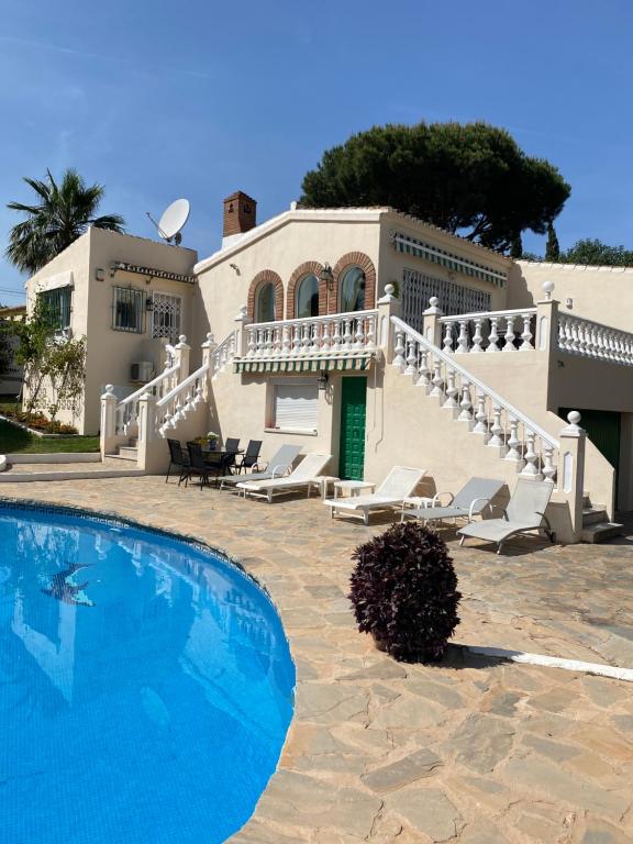 une maison avec une piscine en face d'une maison dans l'établissement Villa Ardilla, à La Cala de Mijas
