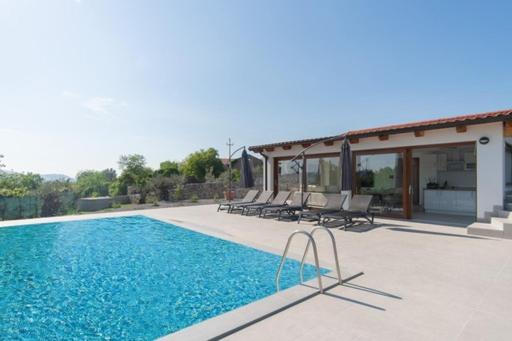 una piscina con sillas junto a una casa en Villa Rosemary Trieste HerMes arT, en Sežana
